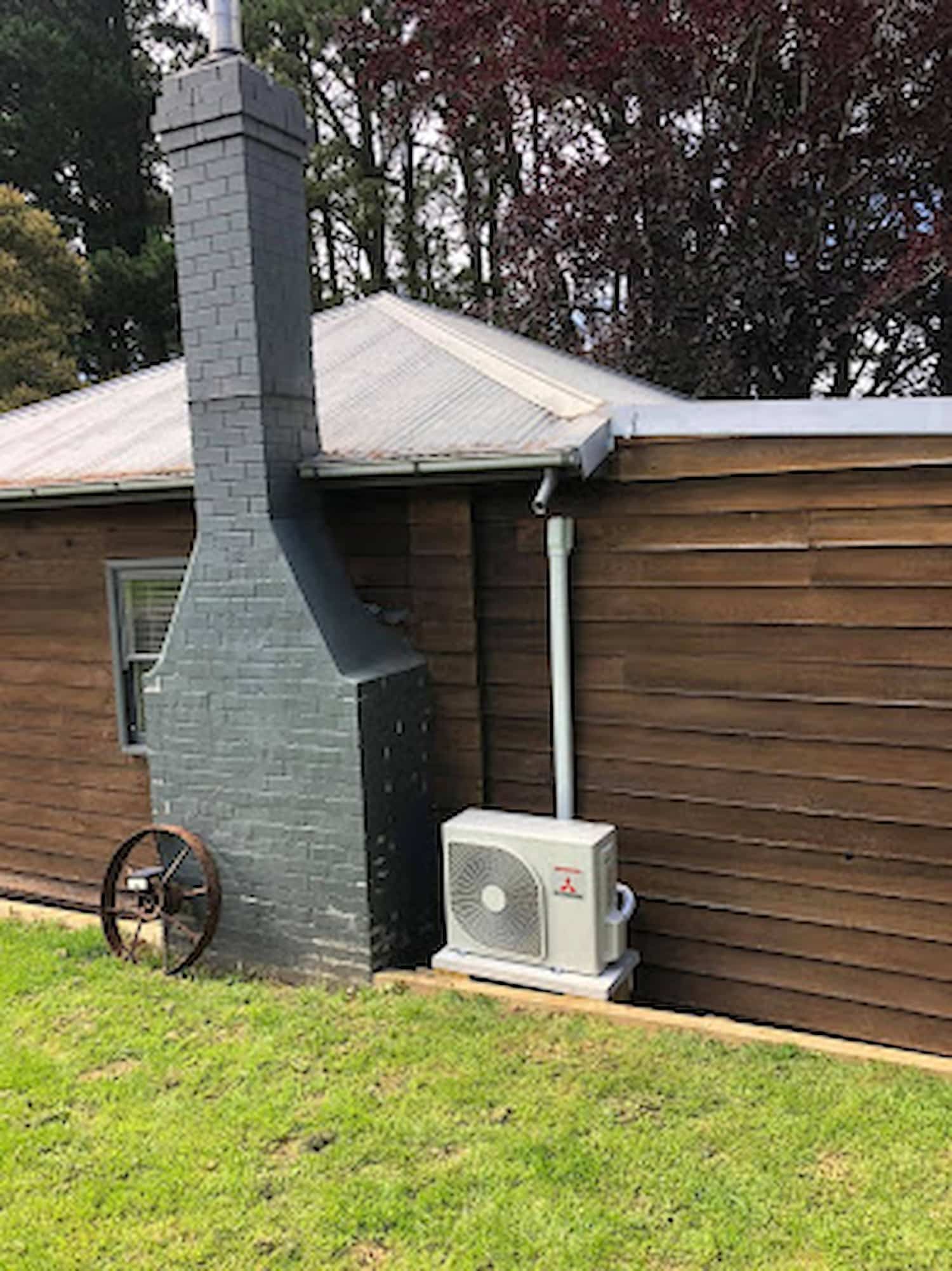 A House With a Chimney and a Fan on the Side of It — Steve's Air Conditioning in Lakeside Dr, NSW