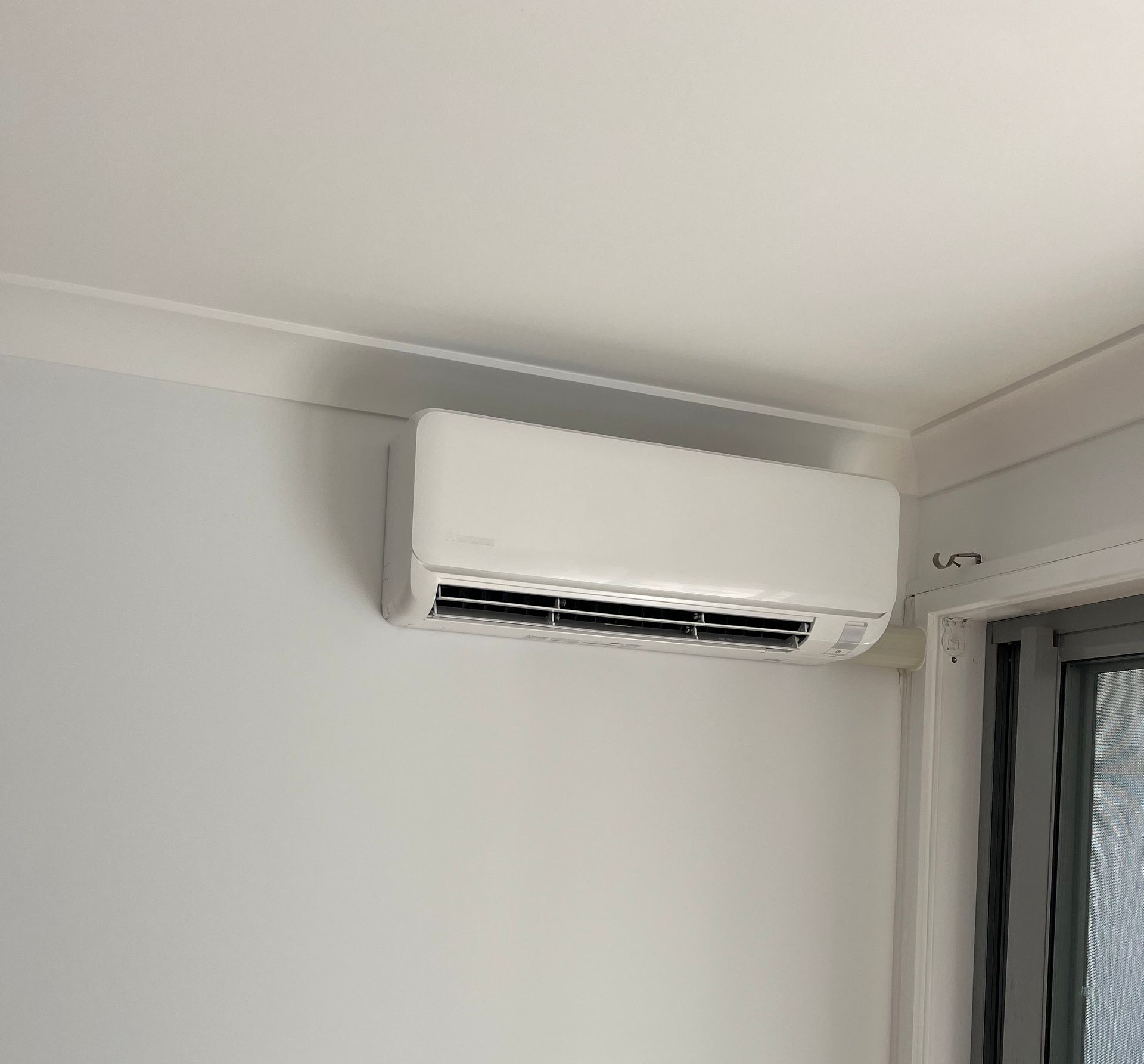 A Man is Working on an Air Conditioner With a Screwdriver — Steve's Air Conditioning in Corrimal, NSW