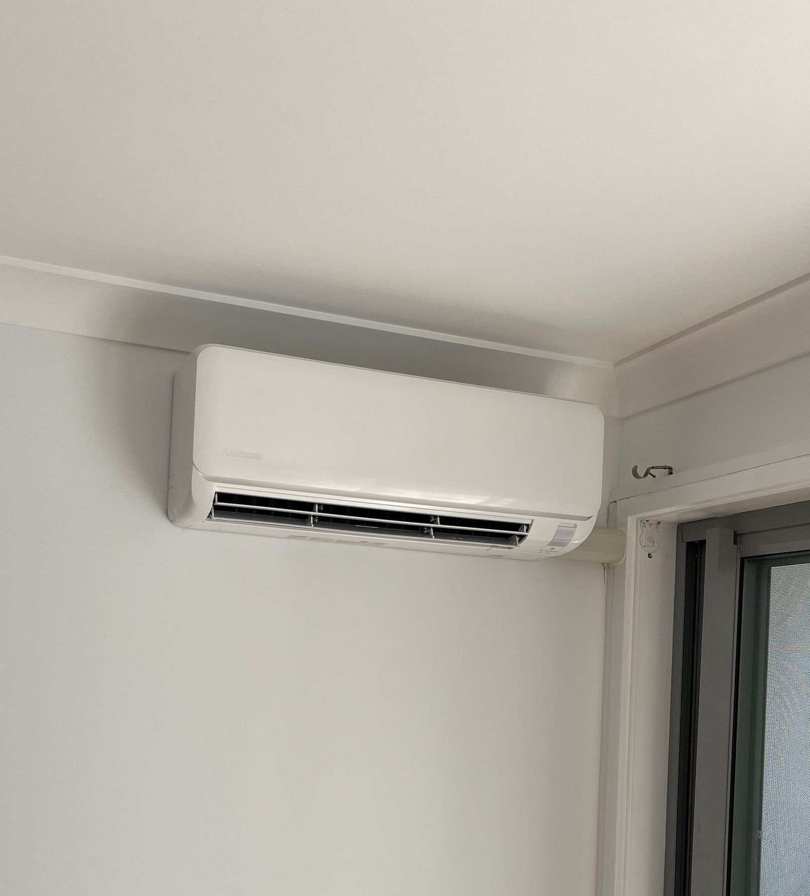 A Person Wearing Blue Gloves is Cleaning an Air Conditioner With a Pink Brush — Steve's Air Conditioning in Wollongong, NSW