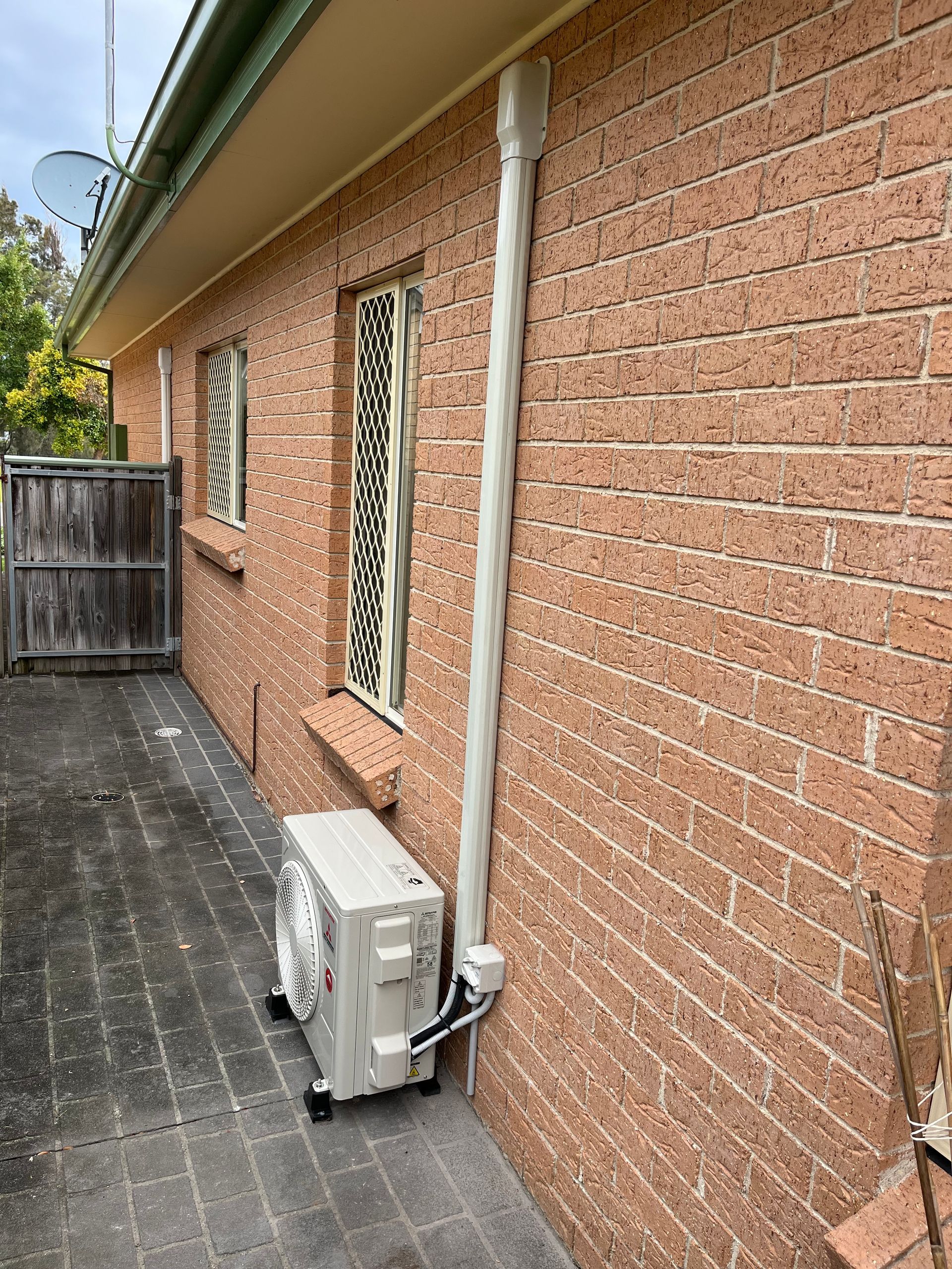 A brick building with a fan on the side of it.