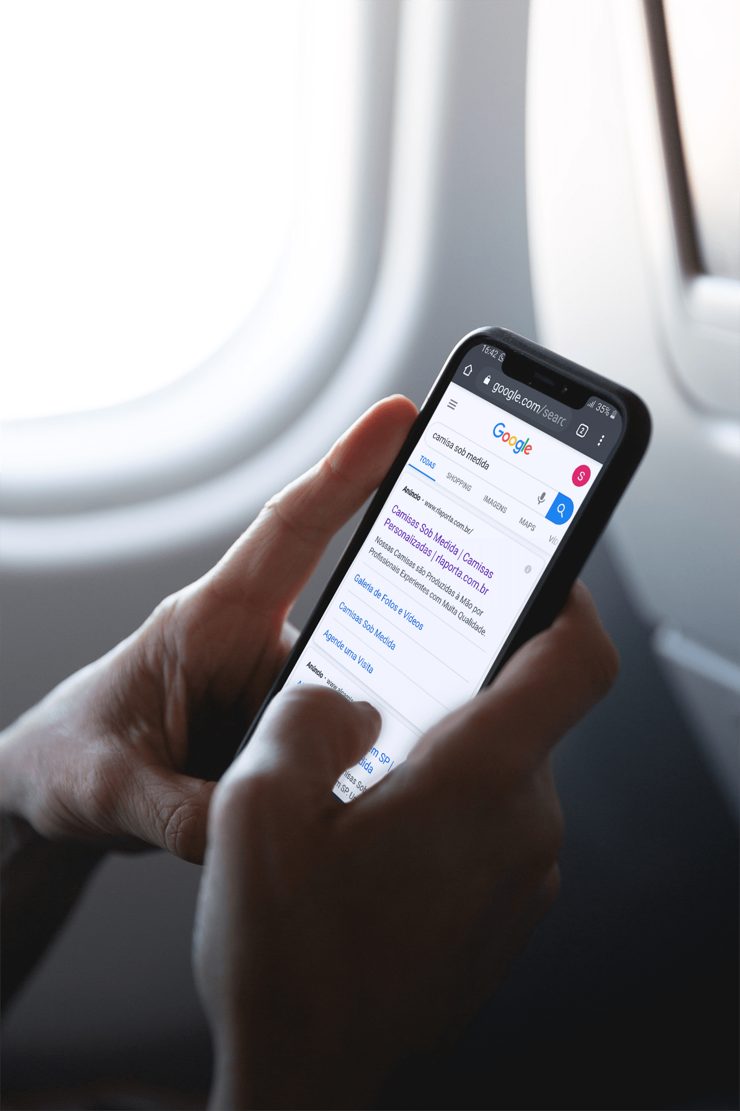 Uma pessoa está usando um telefone celular em um avião.