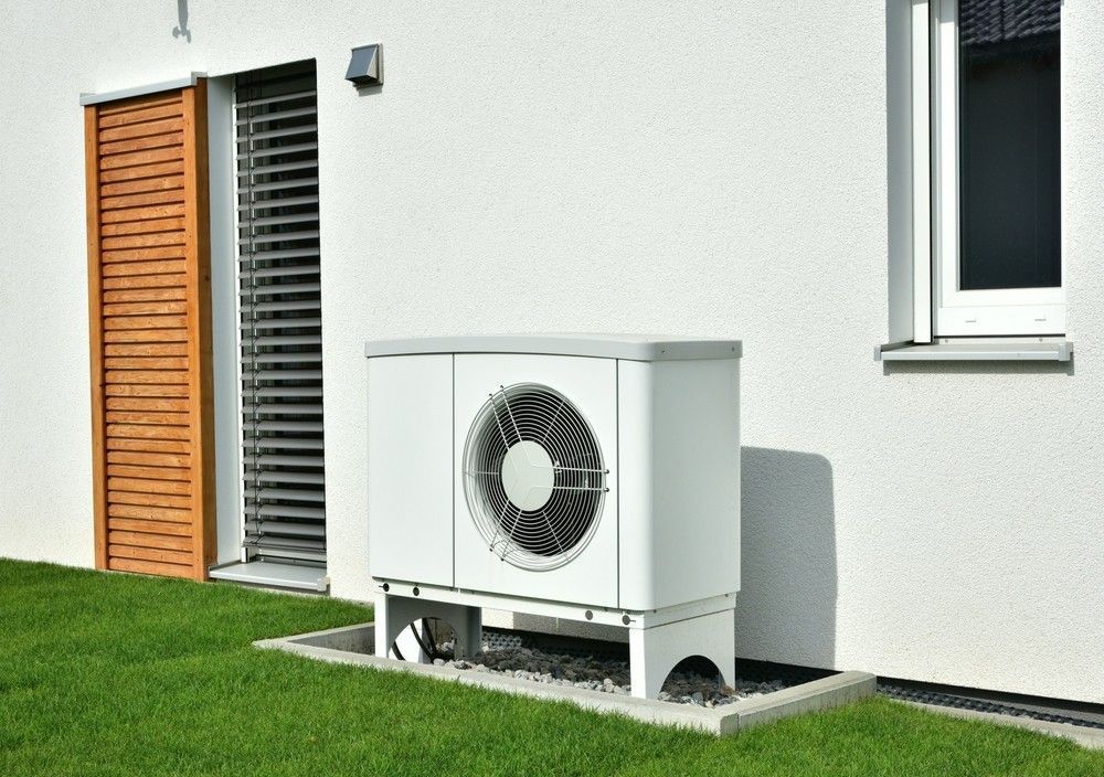 A White Heat Pump Unit Outside a House — Magneto HVAC in Portsmith, QLD