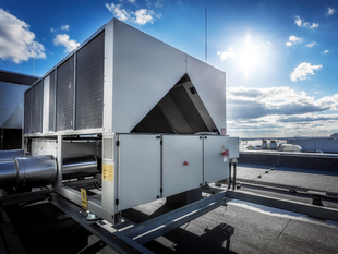 Rooftop HVAC unit under a bright blue sky.