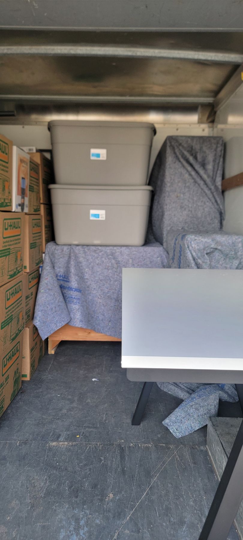 A moving truck filled with boxes and a desk.
