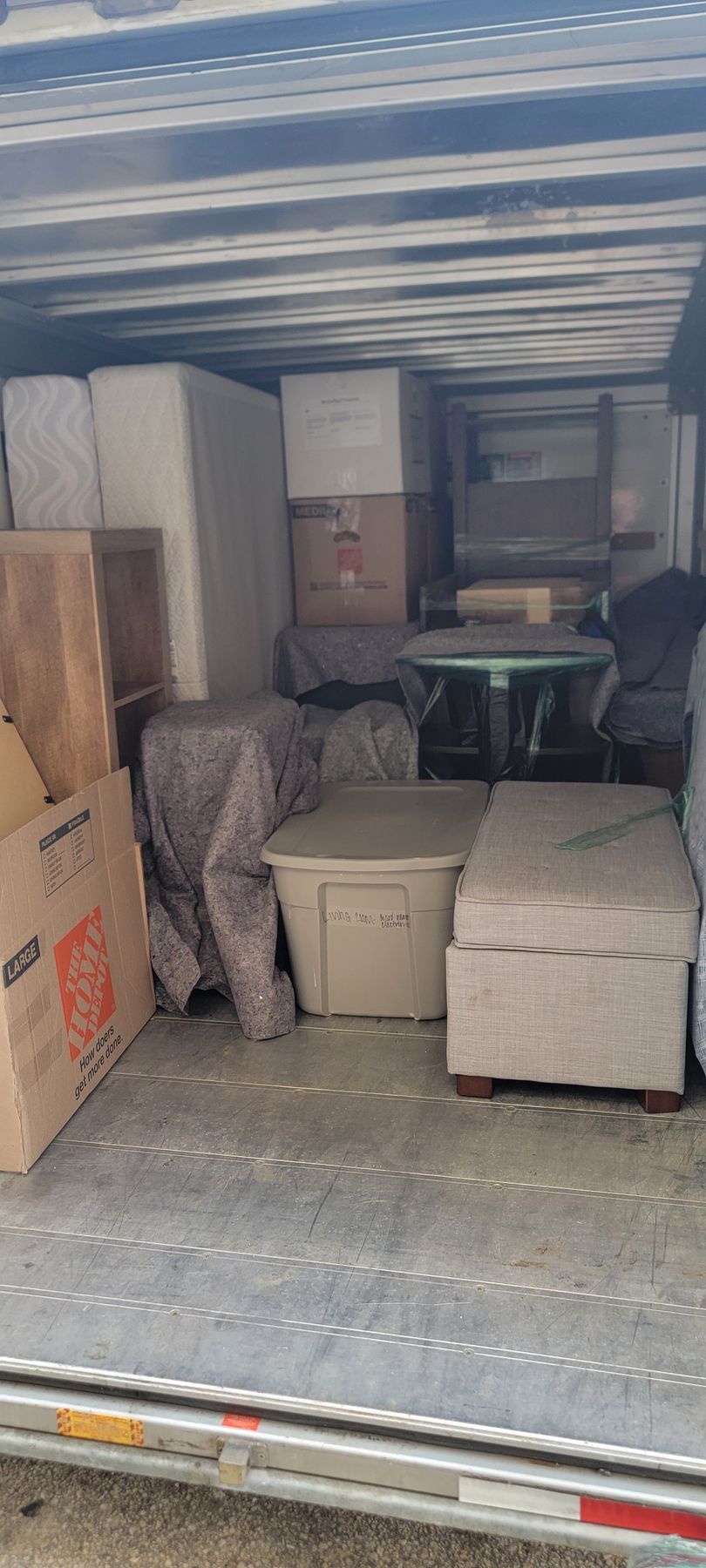 The back of a moving truck filled with furniture and boxes.