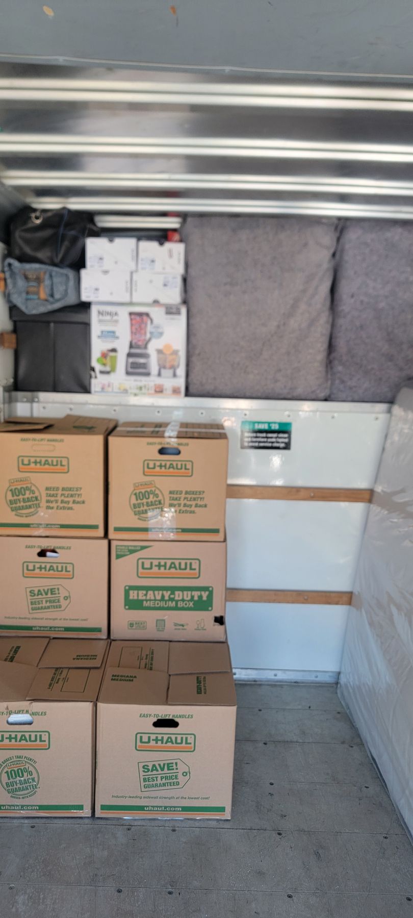A bunch of cardboard boxes are stacked on top of each other in a moving truck.