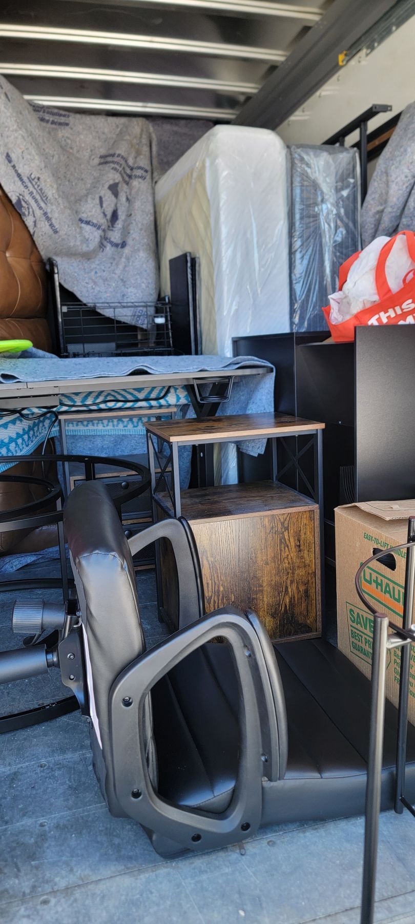 A moving truck filled with lots of furniture and boxes.