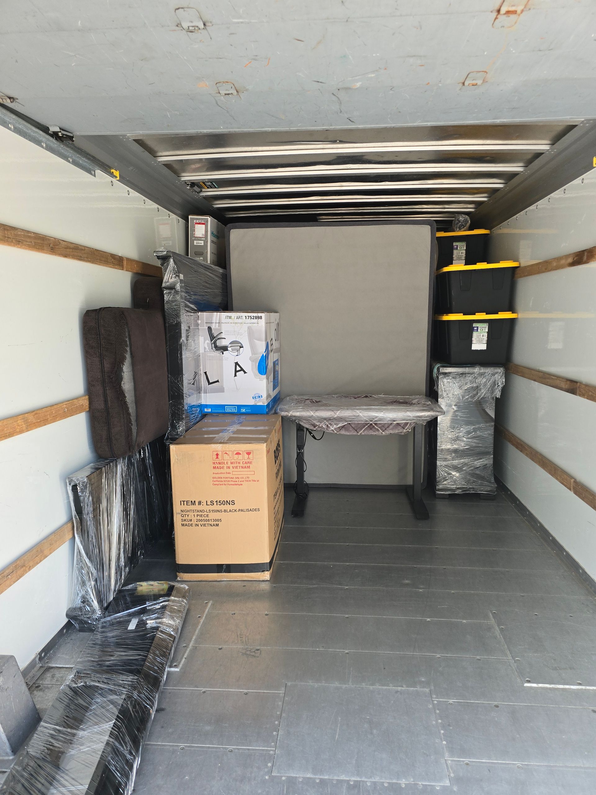 The inside of a moving truck filled with boxes and a table
