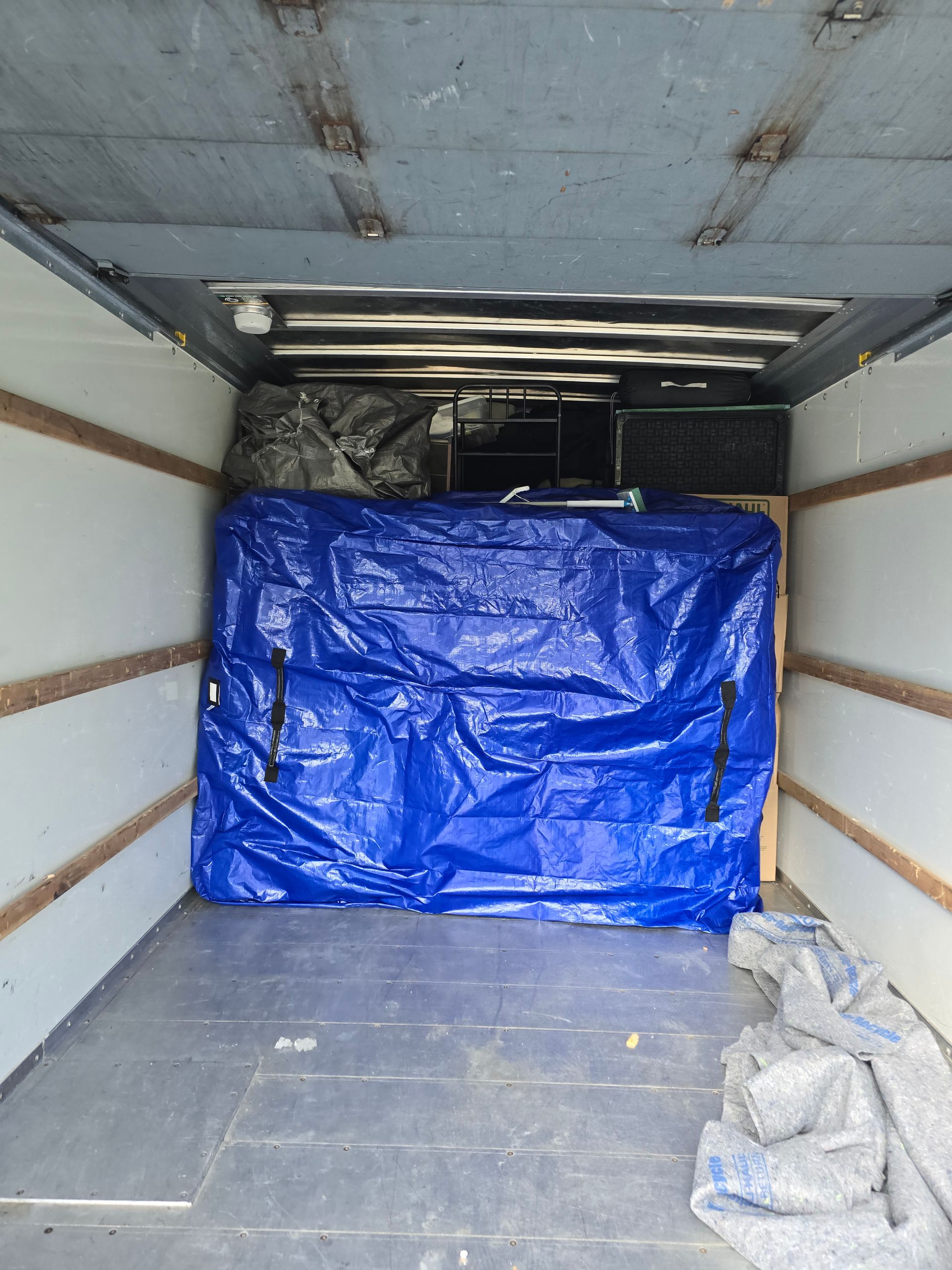 A blue tarp is covering the inside of a truck