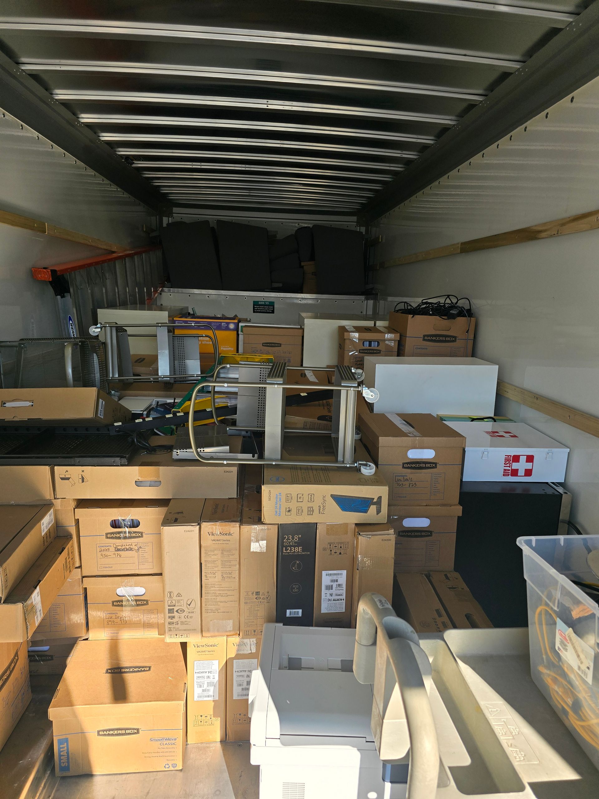 The inside of a moving truck filled with boxes and furniture.