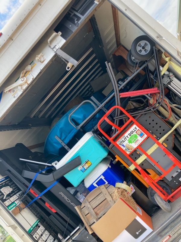 A bunch of stuff in a truck including a fruit picker