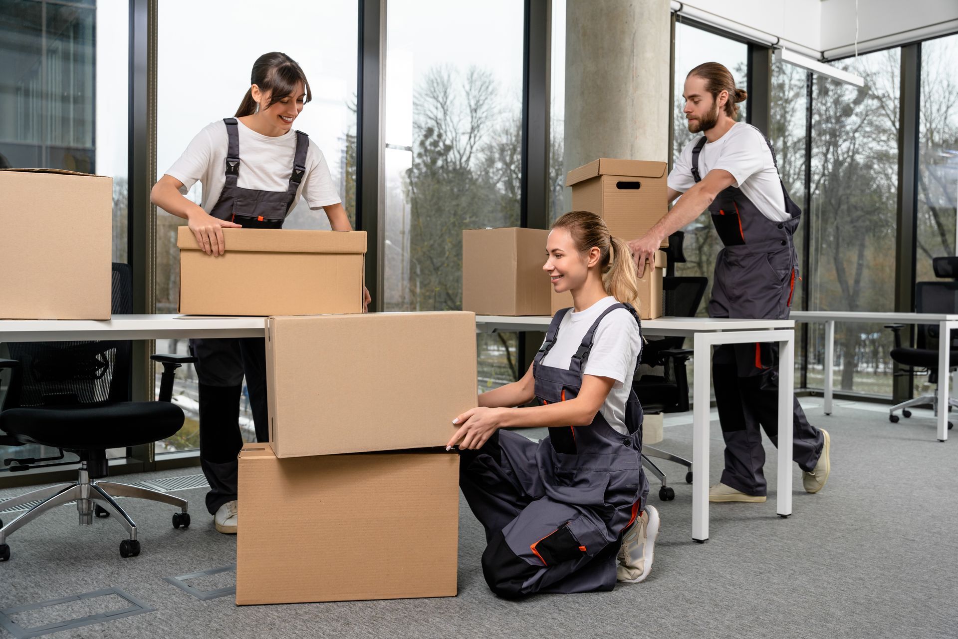 A group of people are moving boxes in an office.