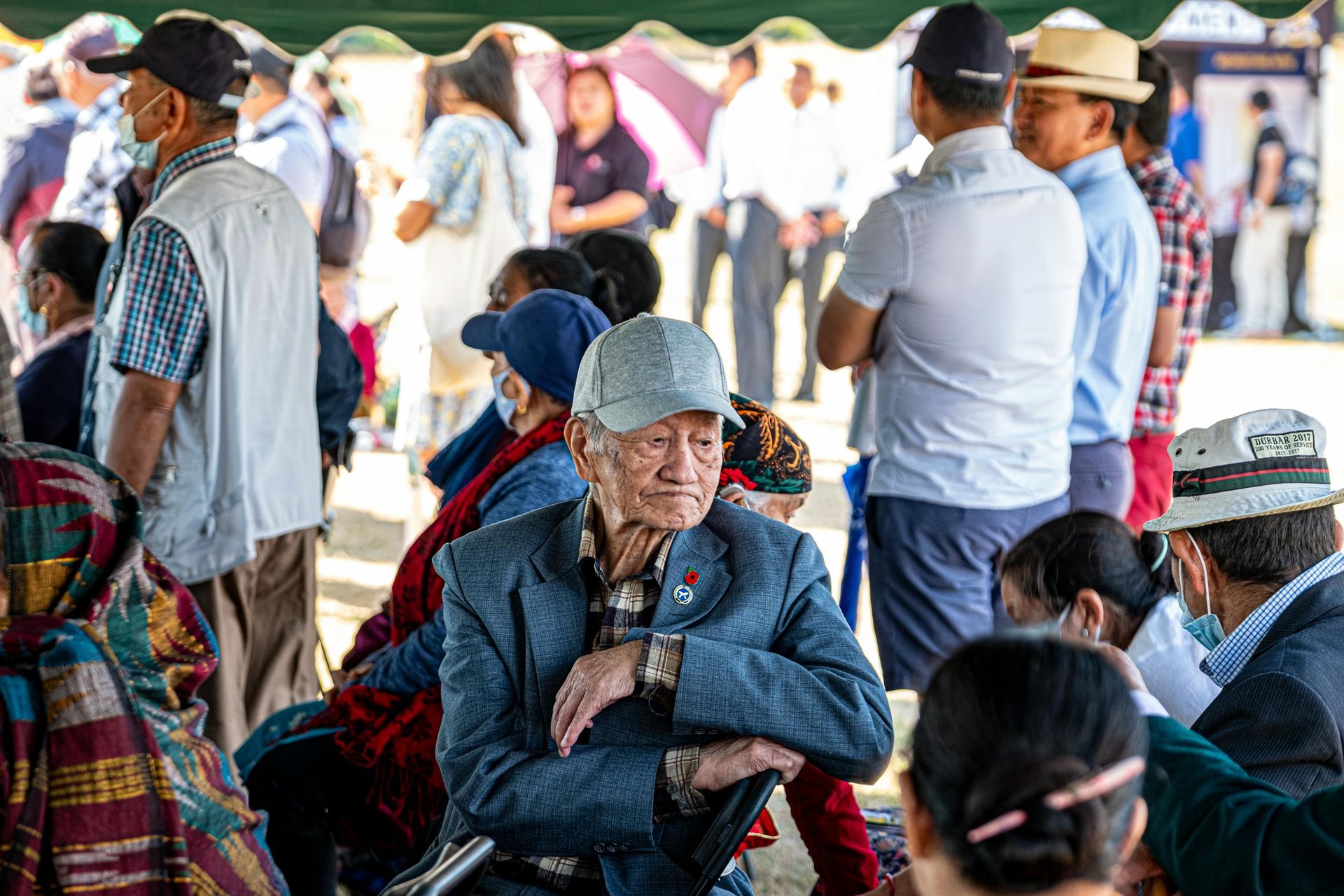 A group of people are sitting under a tent.