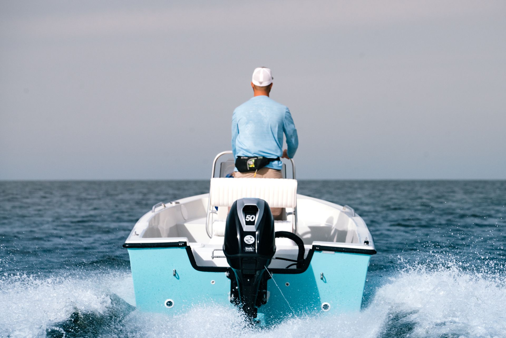 A row of sailboats are docked in a marina.
