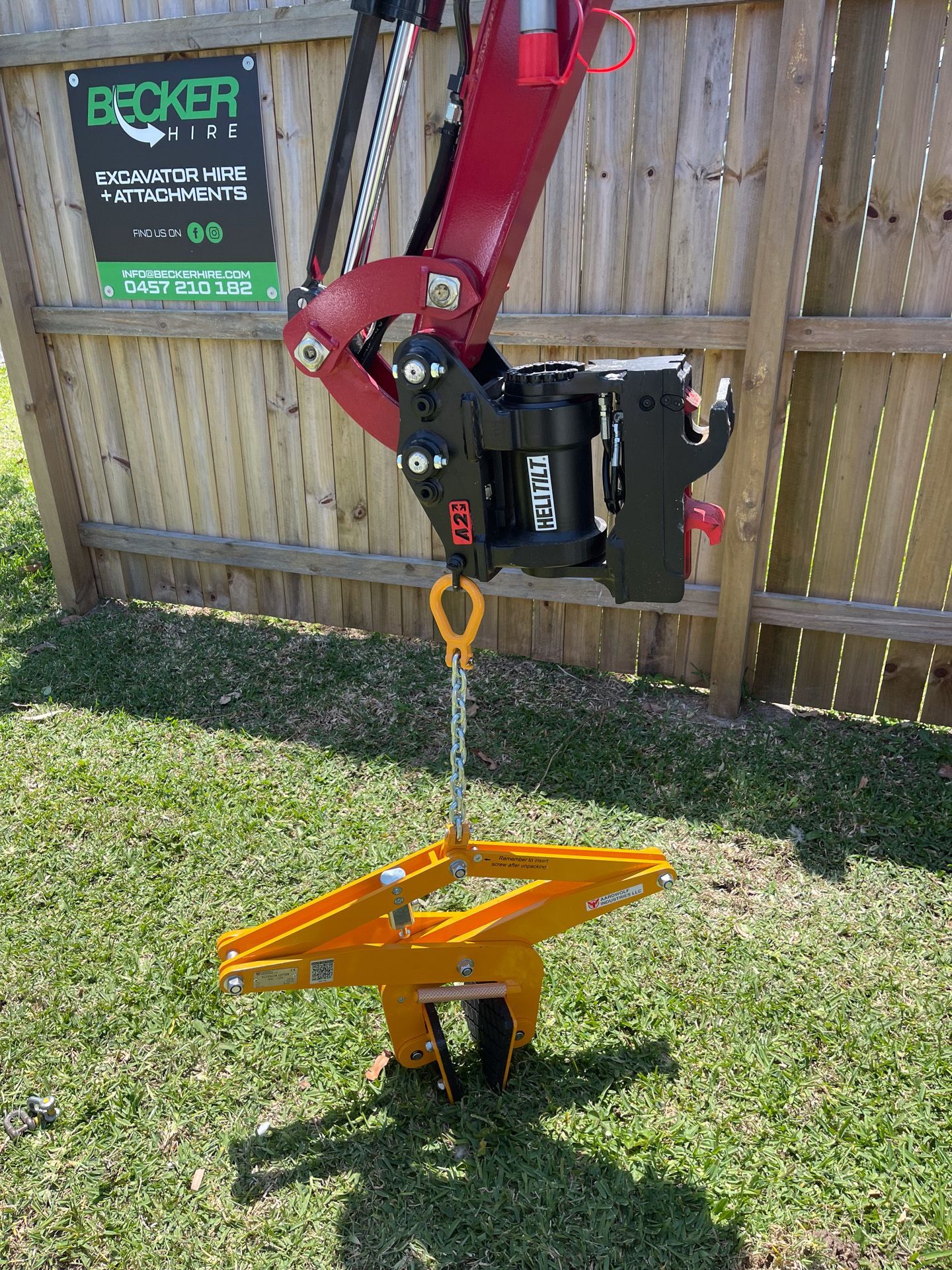 Red excavator on a construction site; license plate reads T392C3.