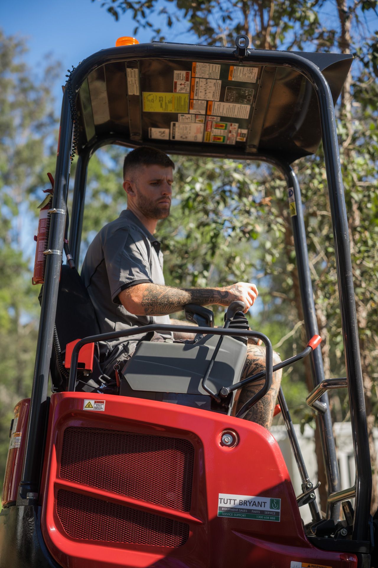 A small excavator bucket scoops up dirt in an outdoor setting.