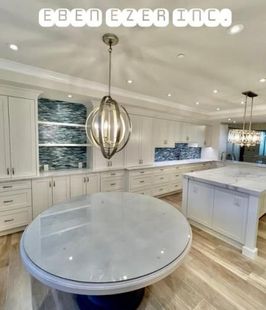 A kitchen with white cabinets and a large round table