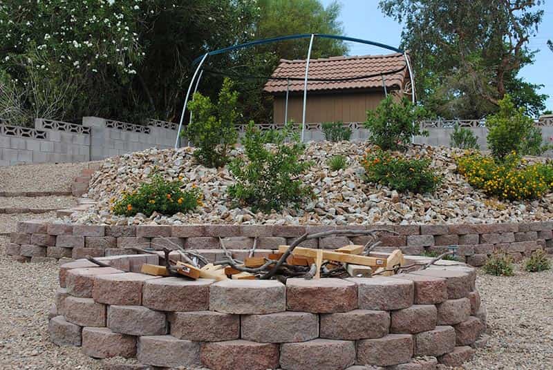Stone Fire Place and Plants in the Background - Custom Landscape Design Services in Henderson, NV