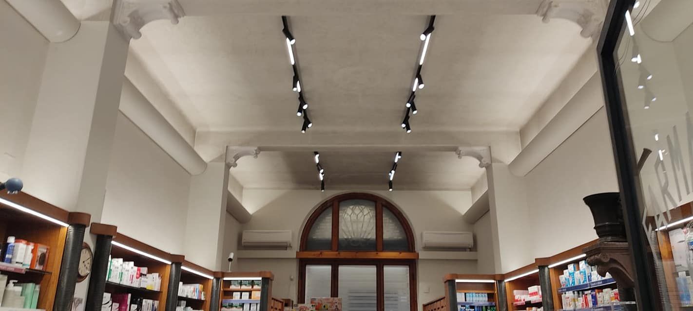 Una farmacia con molti scaffali e luci sul soffitto.