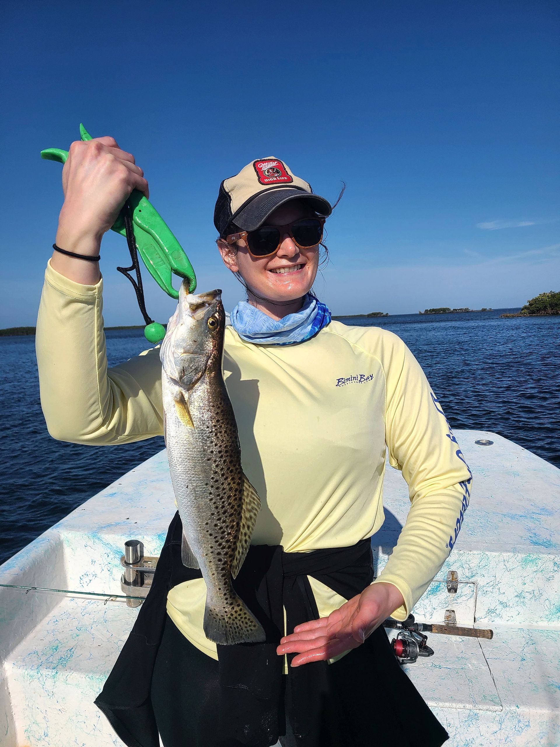 A woman is holding a fish on a boat.