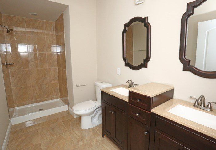 The Grand - Bathroom with two sinks, shower and toilet