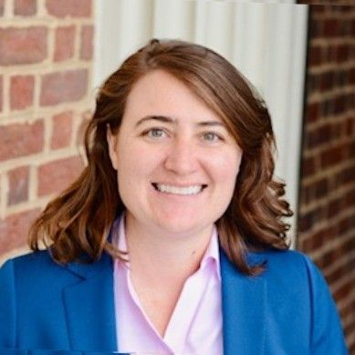 A black and white pencil drawing of a smiling woman with long hair.