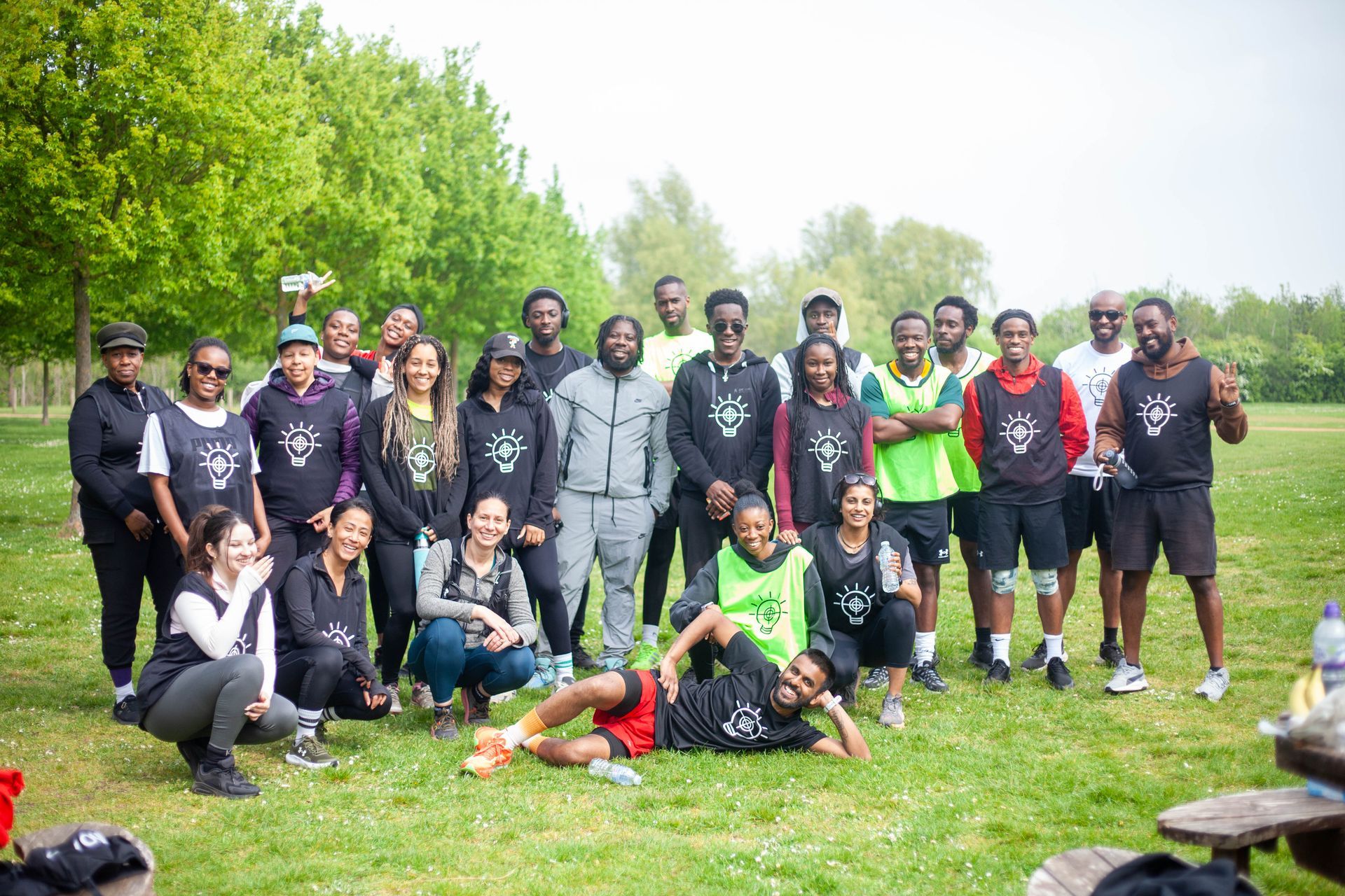 Basketball player dribbling a ball on a court; green shoes, gray shirt, black shorts.