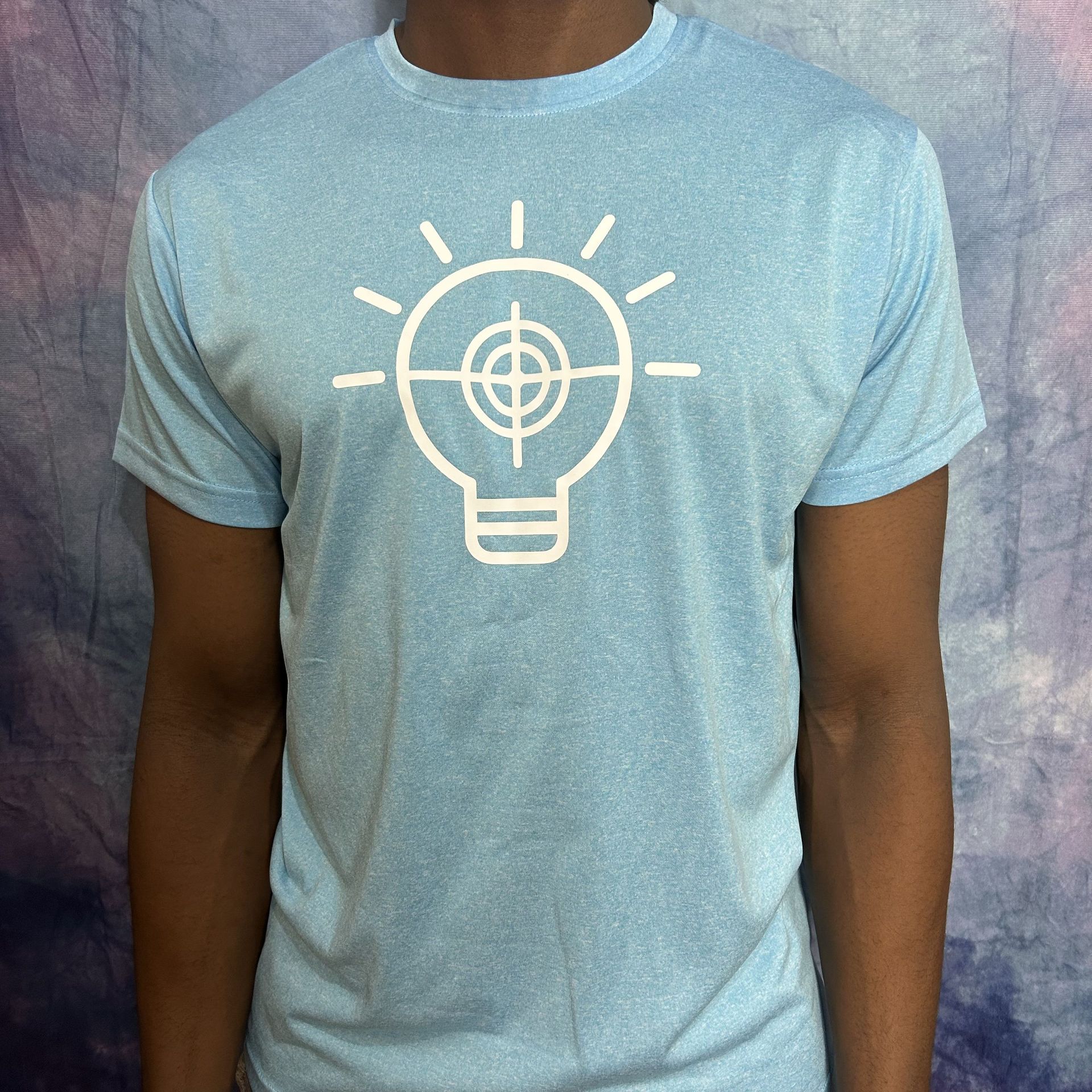 Man wearing a light blue t-shirt with a white lightbulb-shaped graphic that has a target inside.