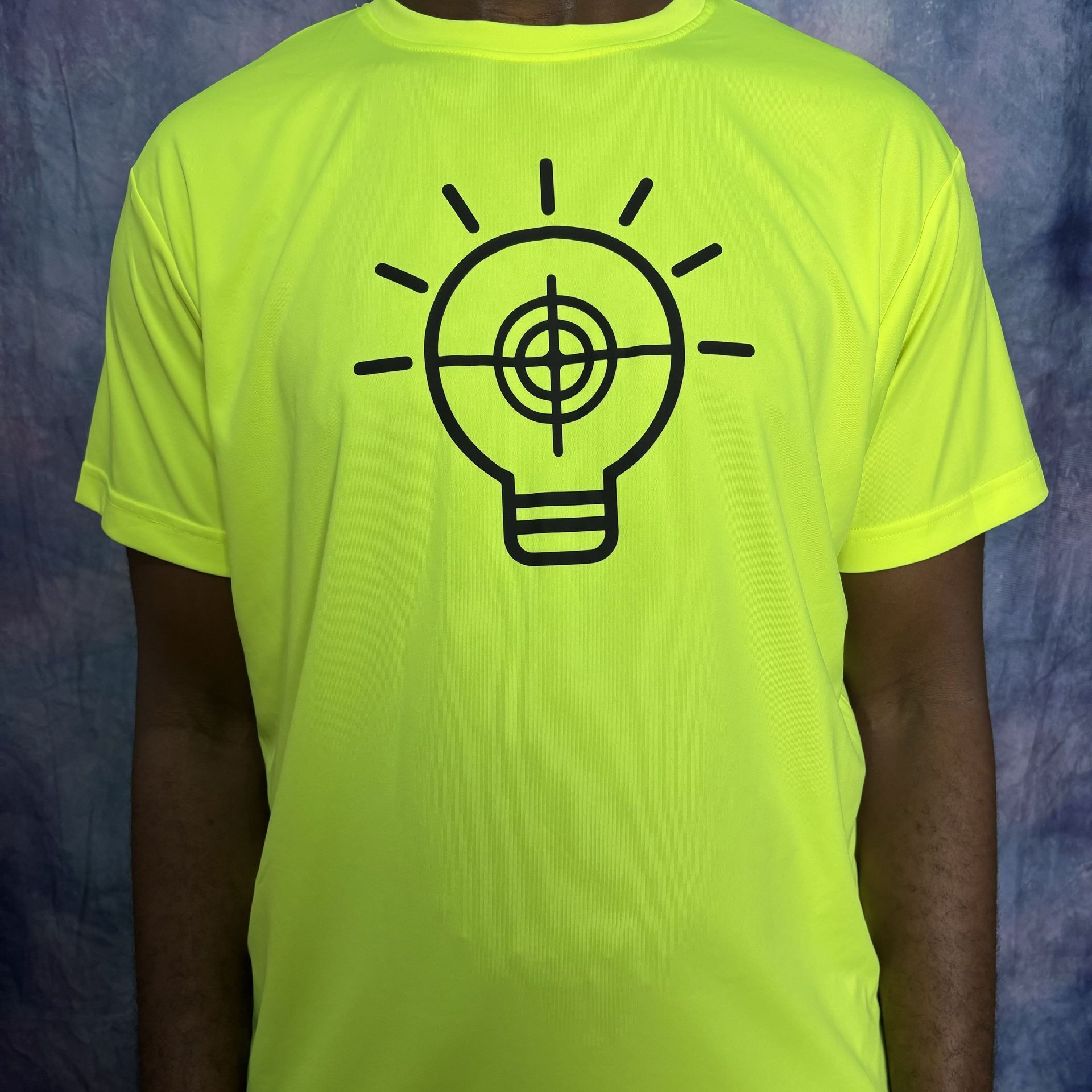 Bright yellow t-shirt with a black lightbulb design, featuring a target in the center.