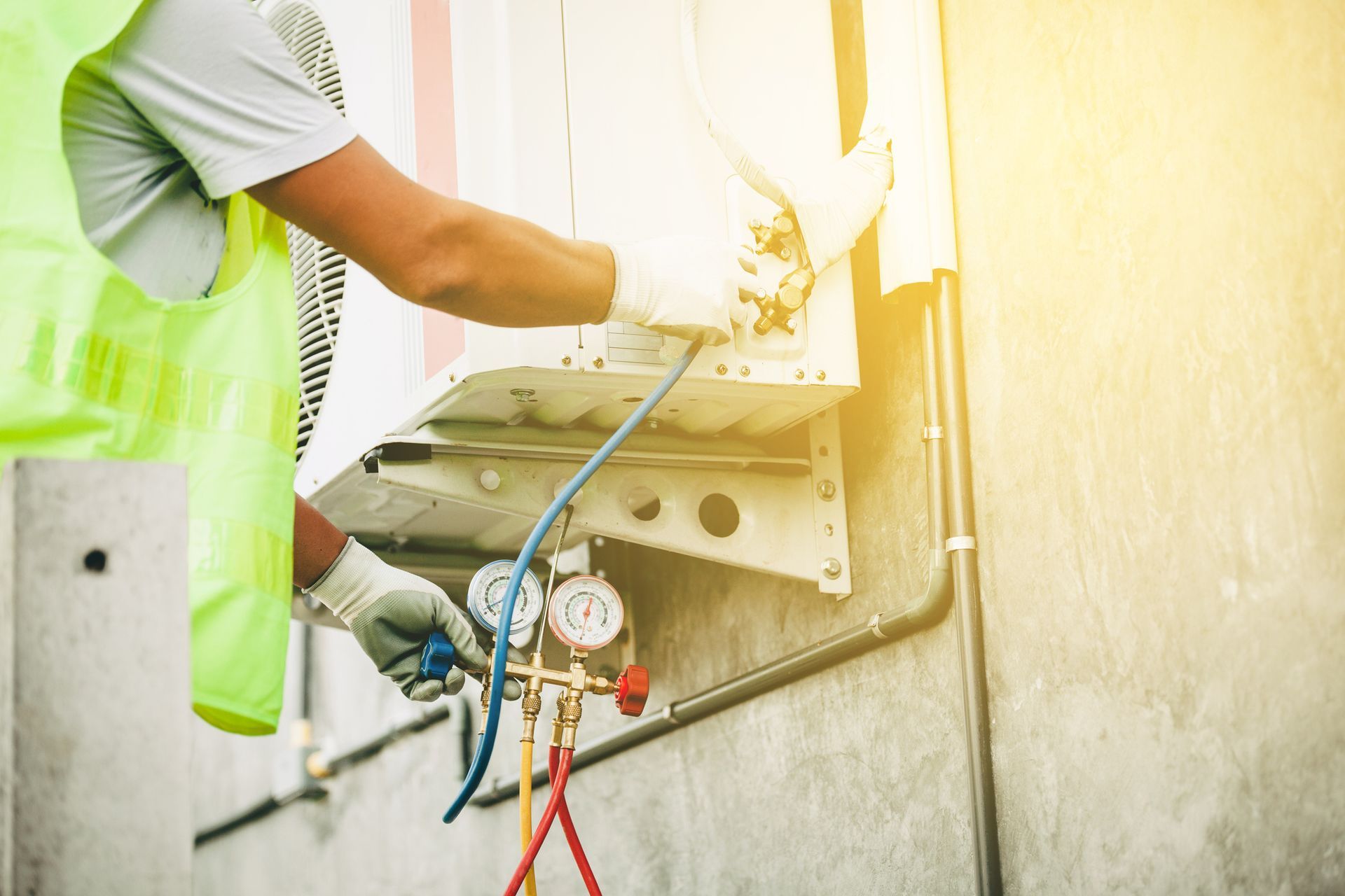 AC contractor in a safety vest with a measuring device, preparing to install new air conditioner.