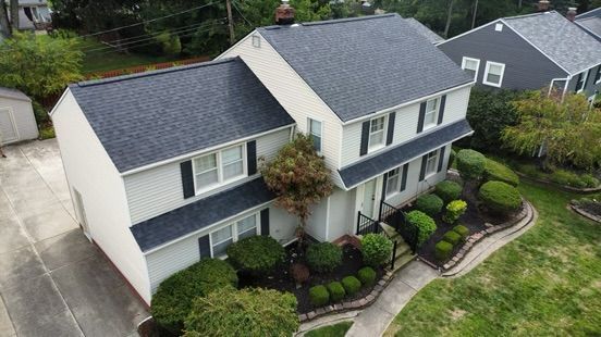 A team of siding contractors installing new siding on a residential home, using professional tools to ensure precise alignment and a secure finish.