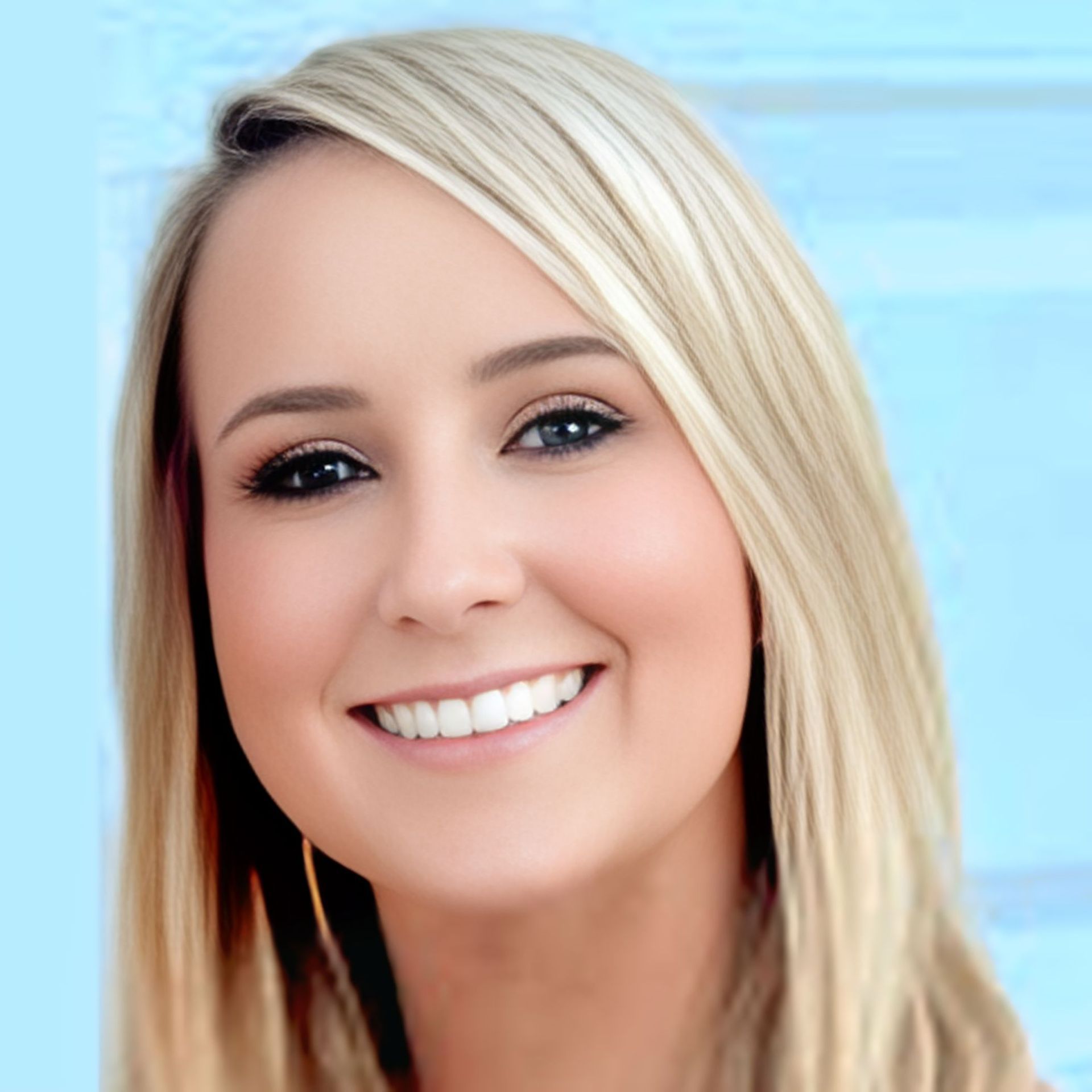 Blonde woman with blue eyes smiling.
