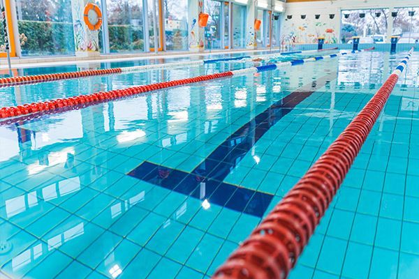 A large indoor swimming pool with red lanes and a life preserver.