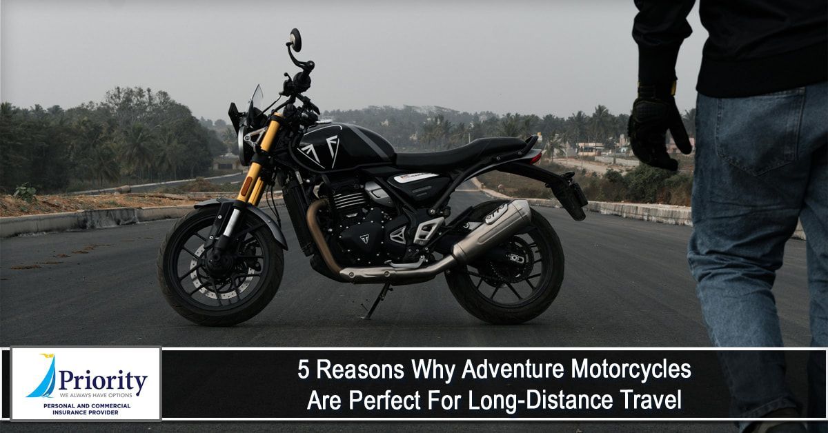 A man is standing next to a motorcycle on the side of a road.