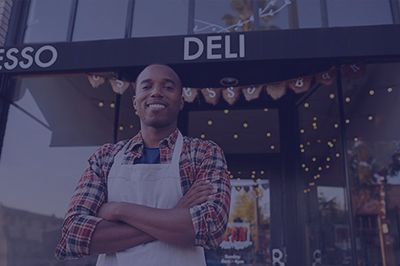 Smiling Black man in apron stands in front of an