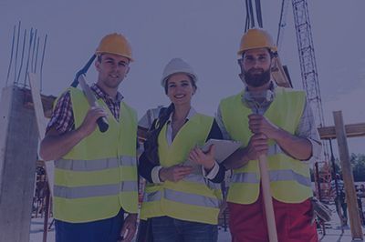 Construction workers wearing hard hats and safety vests at a construction site.