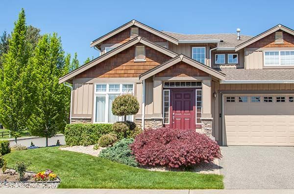 A large house with a red door and a garage.