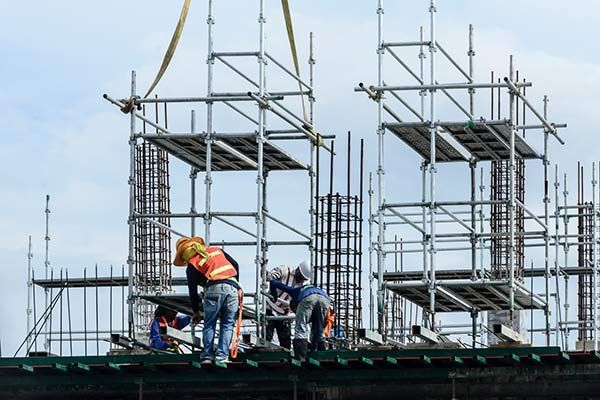 A group of construction workers are working on a building under construction.