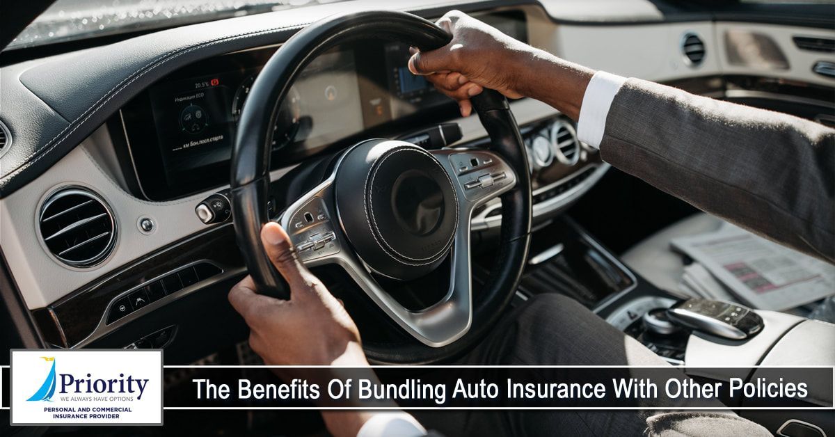 A man in a suit is driving a car and holding the steering wheel.