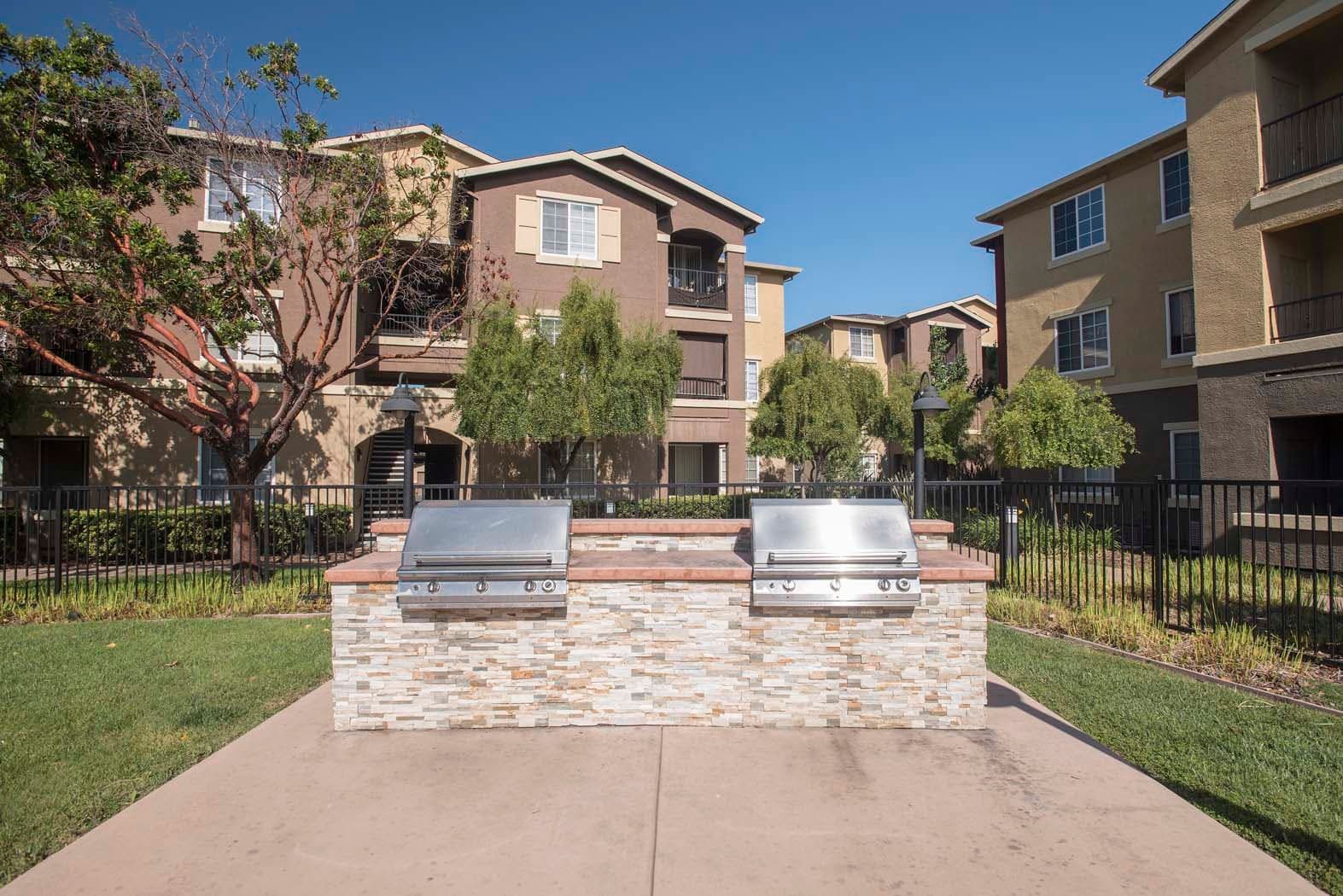 Outdoor community grilling area with two BBQ grills