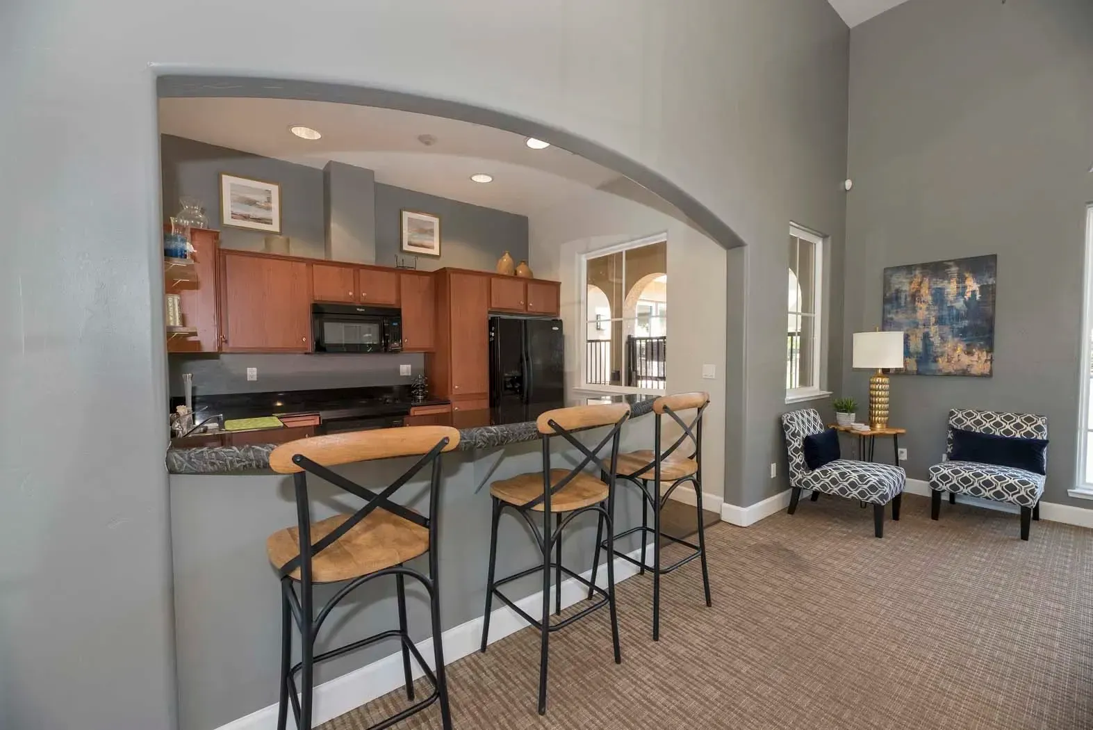 Stylish apartment interior showcasing a kitchen bar, chairs, and seating area.