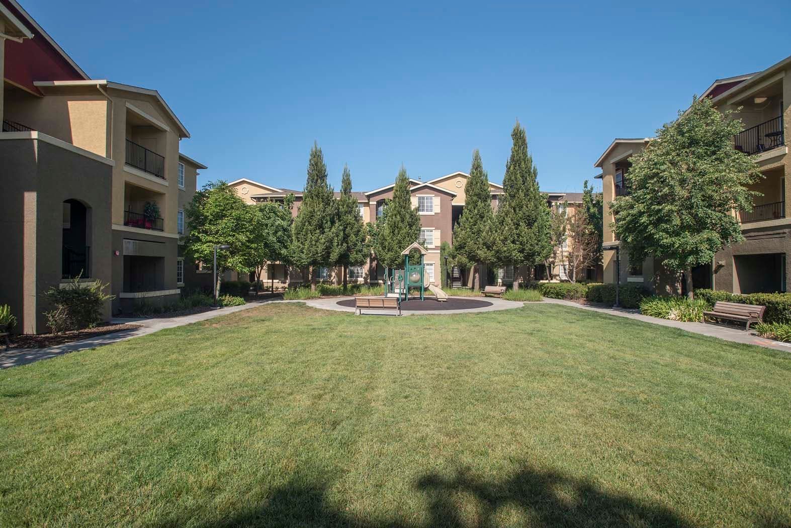 View of a community courtyard with a playground and surrounding apartments.