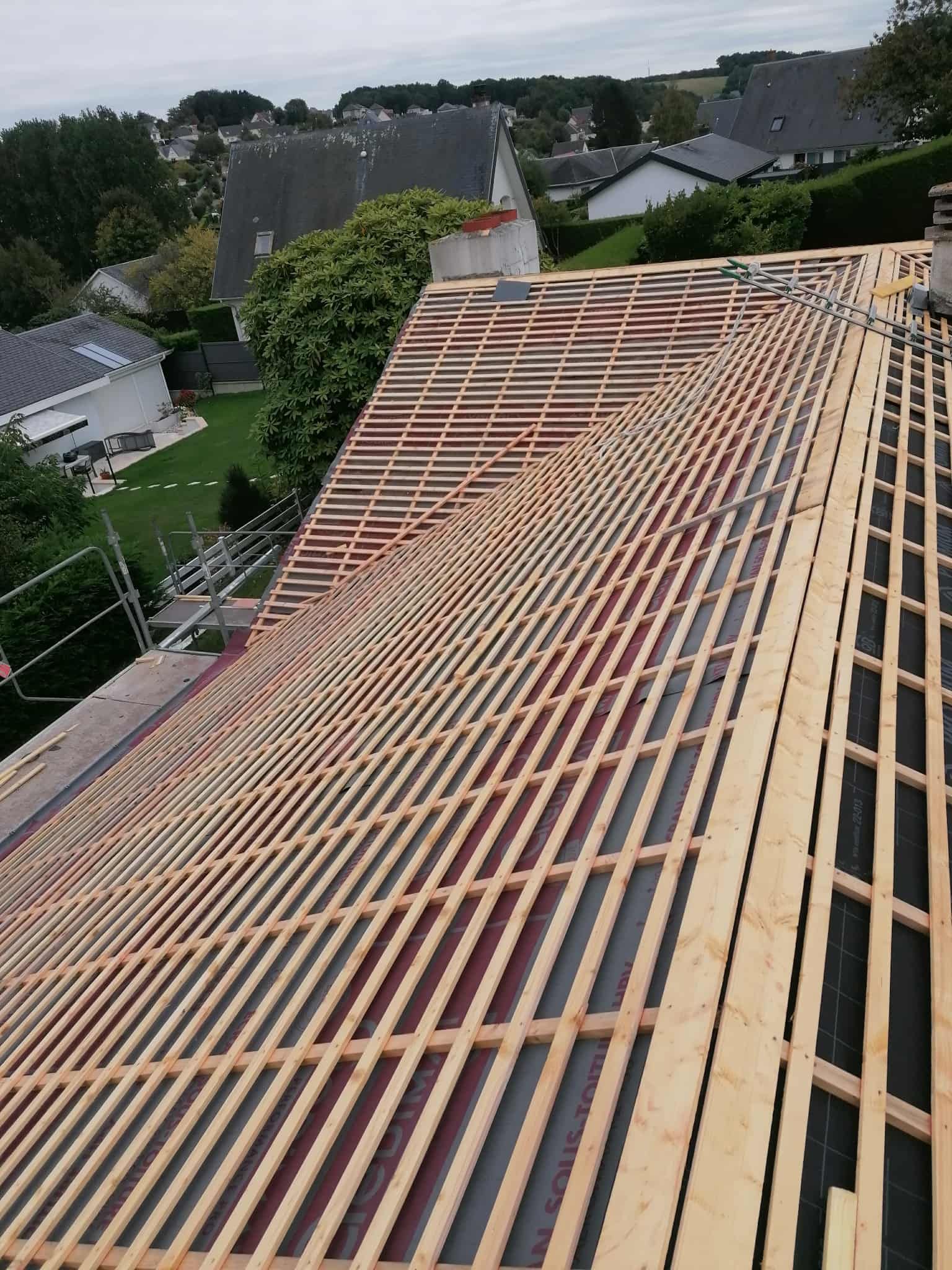 Toiture en construction avec charpente apparente.