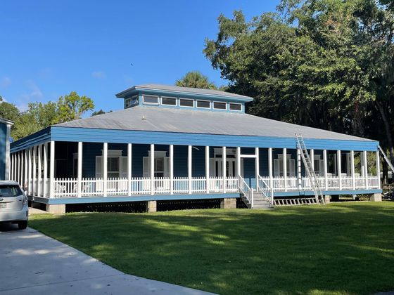 A large blue and white house with a large porch