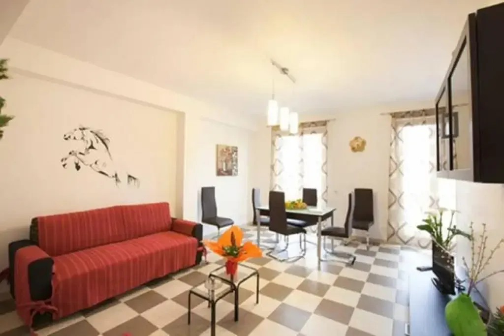 Casa vacanza Nina bright living room with red sofa, dining table, tiled floor, and large windows