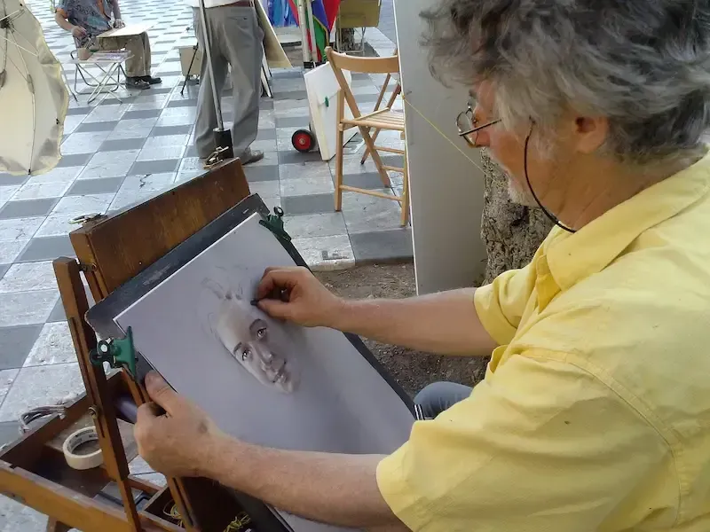 Street artist drawing a portrait in Taormina’s historic center