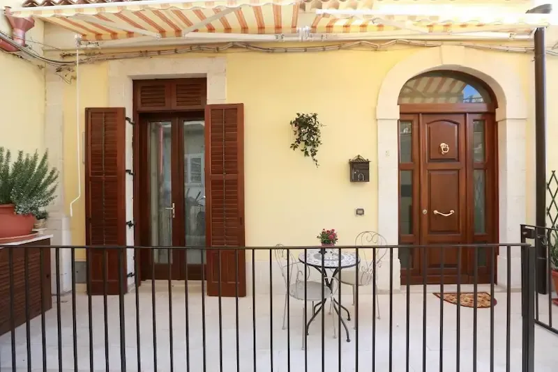 Cozy Sicilian home entrance with outdoor seating and Mediterranean decor in Pozzallo