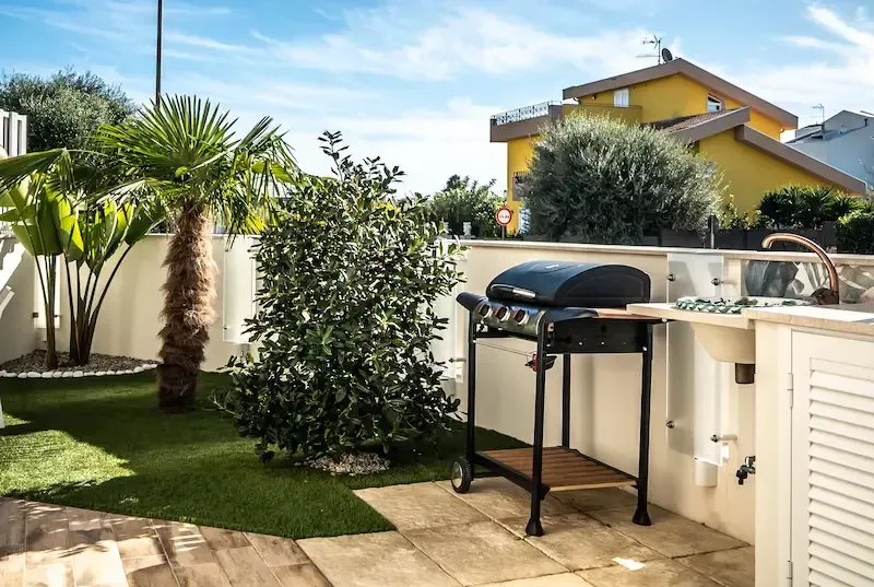 Villa Polares Bianca Pozzallo outdoor barbecue area with gas grill and garden setting