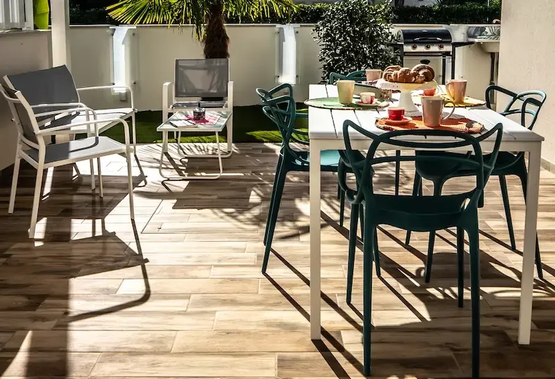 Villa Polares Bianca patio dining area with metal chairs, a white table, and breakfast items in bright sunlight