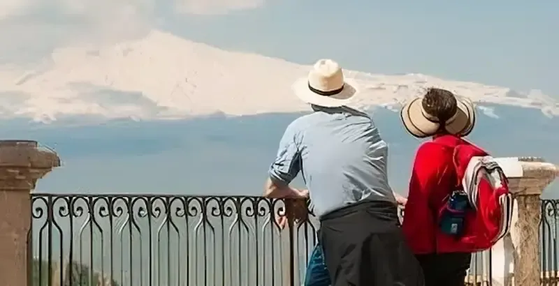 Two people admiring Mount Etna from a panoramic viewpoint
